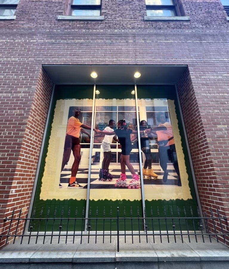 a photographer's work displayed in a large window of a brick building.